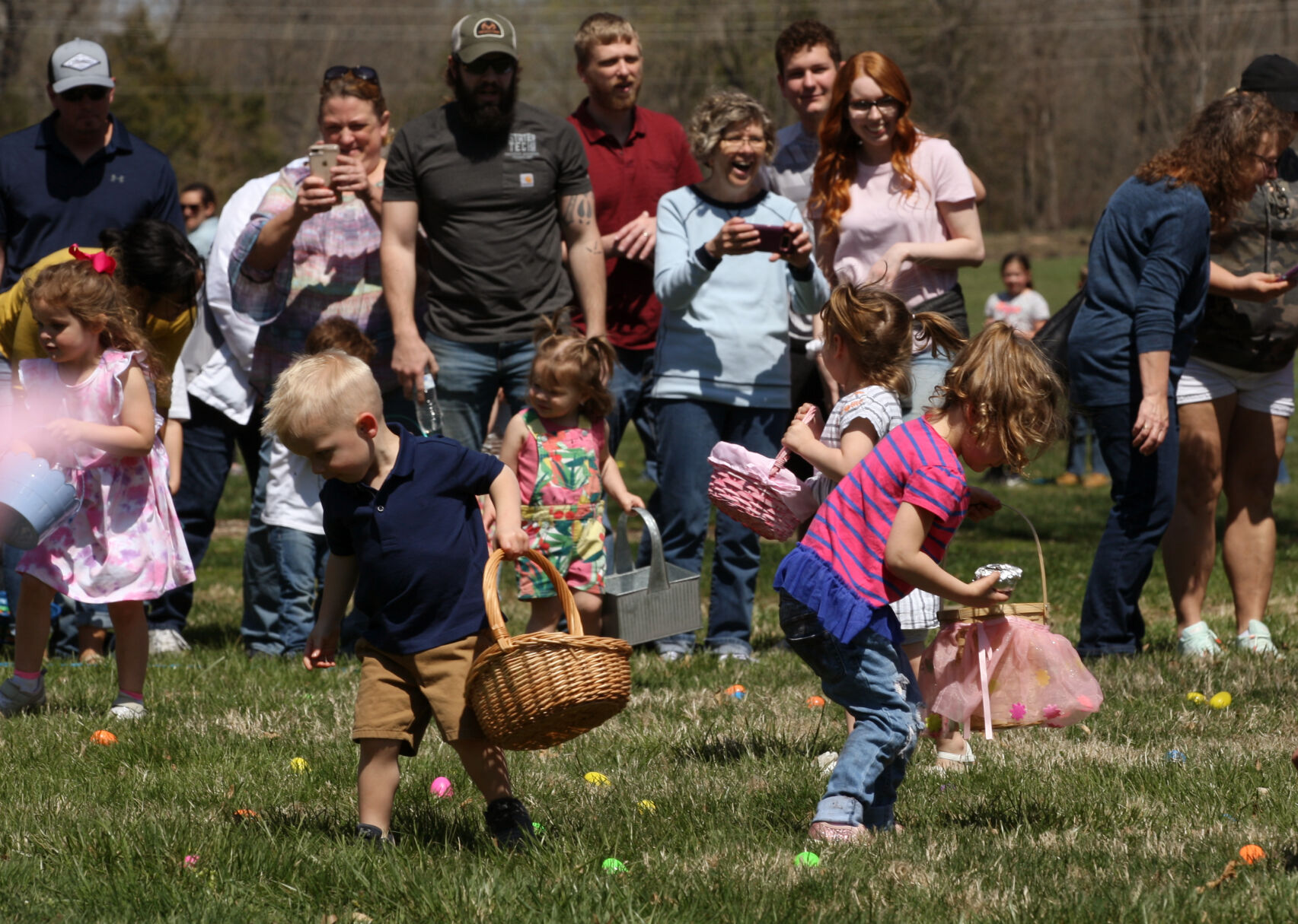 Parents cheer on children during an egg hunt